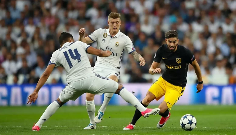 Real Madrid's Carlos Casemiro (left) and Toni Kroos (centre) battle for the ball with Atletico Madrid's Yannick Carrasco
