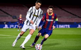Cristiano Ronaldo (L) of Juventus FC is challenged by Lionel Messi of FC Barcelona