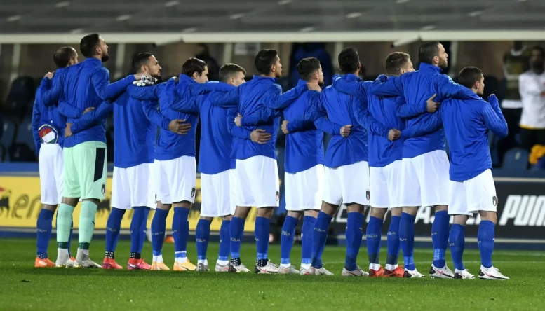 Italian football team players embrace each other during the national anthem, before the Nations League's match