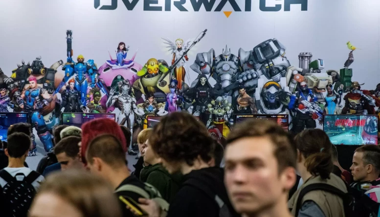 Young people stand in a line to play the Overwatch video game at the Comic Con