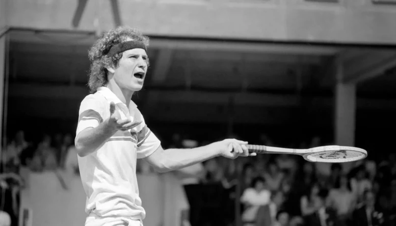 John McEnroe was two flashpoints away from being thrown out of Wimbledon. The number two seed, received one public waring and was then docked 2 penalty points as he beat Tom Gullikson 7-6, 7-