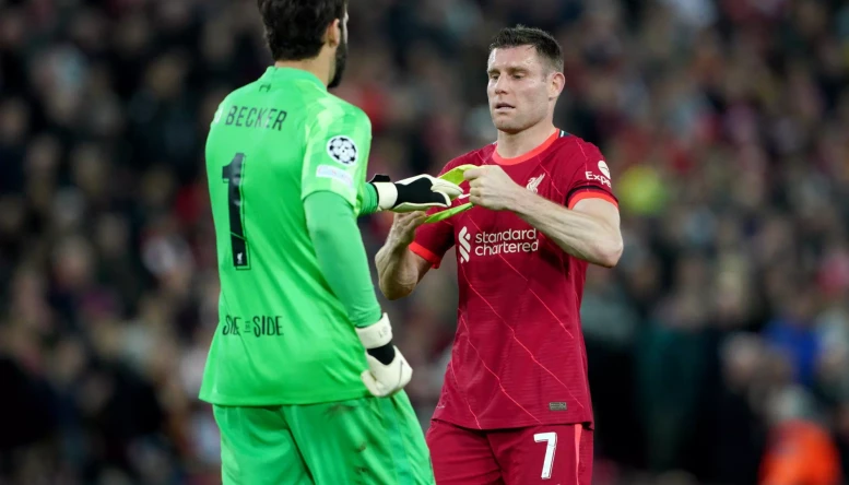 Liverpool's James Milner give the captains armband to goalkeeper Alisson during the UEFA Champions League quarter final