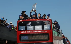 Members of the Ricketts family and the World Series trophy on a double decker bus in 2016