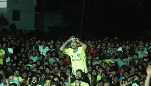 Kerala Blasters Fans watch on a big screen at the football ground at Nainambalappu in Kerala