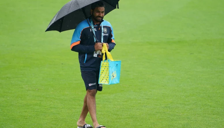 Rohit Sharma takes cover from the rain